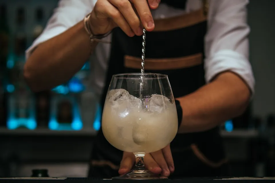 Barman préparant une boisson sur glace au comptoir